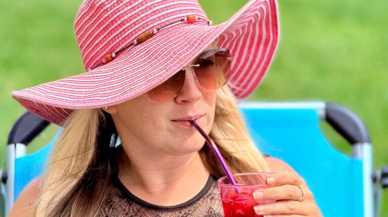 Bildbeschreibung Frau genießt im Liegestuhl einen Coktail